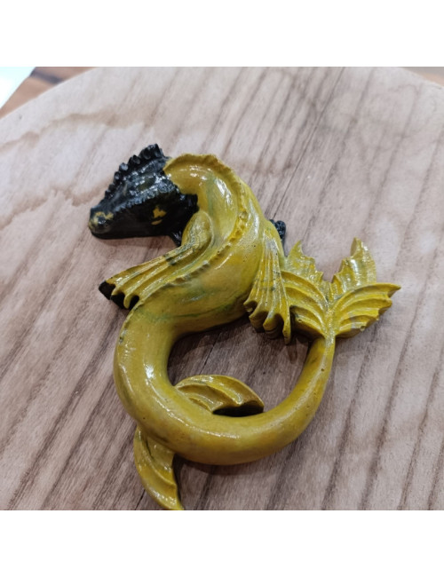 Soleombra est un dragon en résine jaune et noir, au style aquatique et mystérieux, évoquant la dualité entre la lumière et l'obs